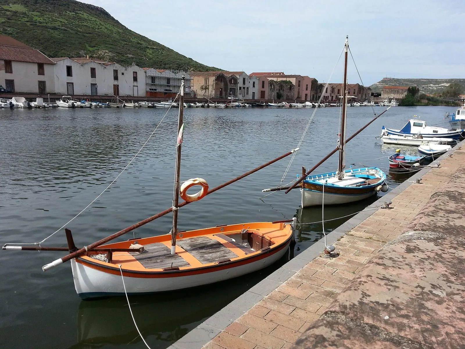 Barche di legno ormeggiate lungo il fiume Temo a Bosa, con le antiche concerie sulla riva opposta