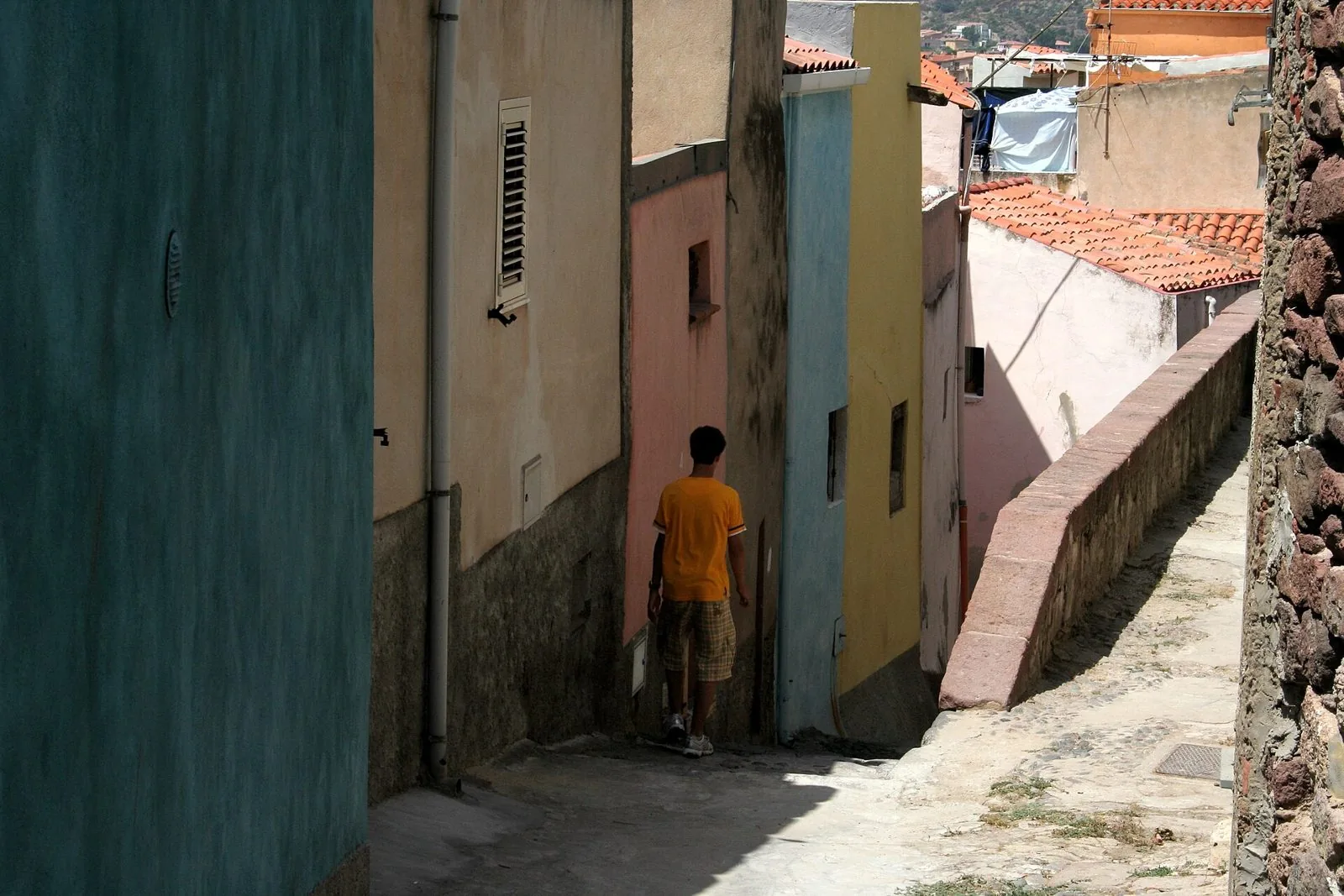 Vicolo in salita del centro storico di Bosa con case colorate e tetti in coppi