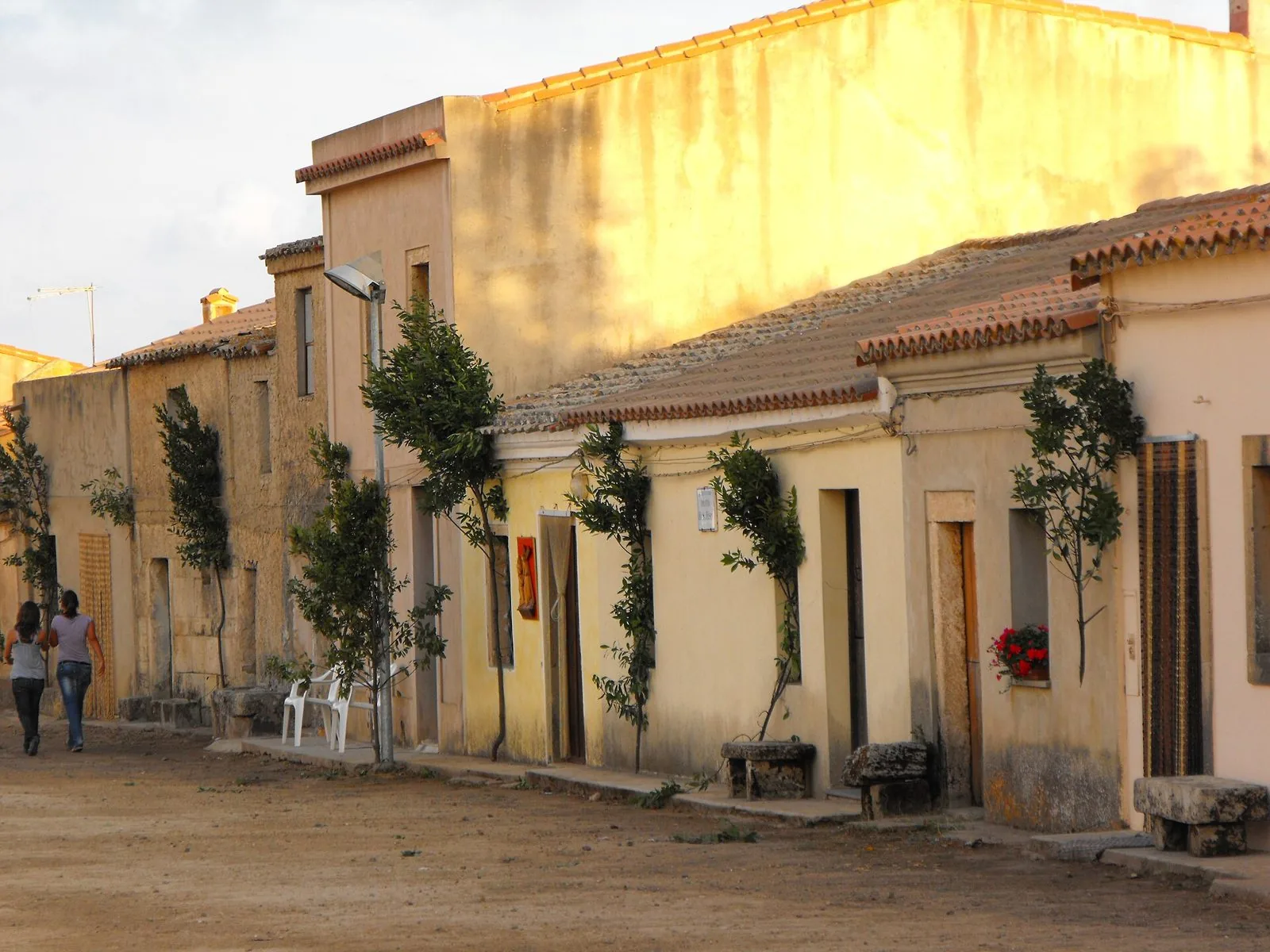 Strada sterrata con le casette basse del villaggio di San Salvatore di Sinis al tramonto